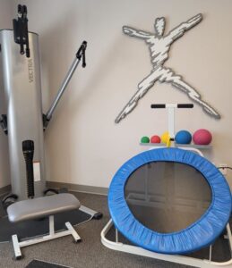 Physical therapy exercise area with balls and trampoline.